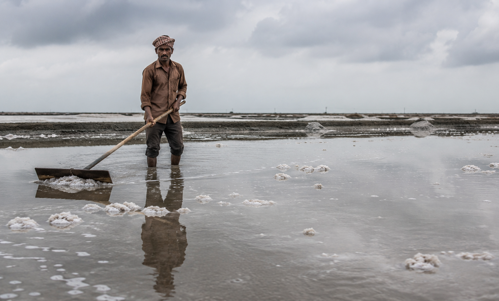 Salt-pan worker in Kutch standing in brackish water, a high-risk occupational exposure for leptospirosis